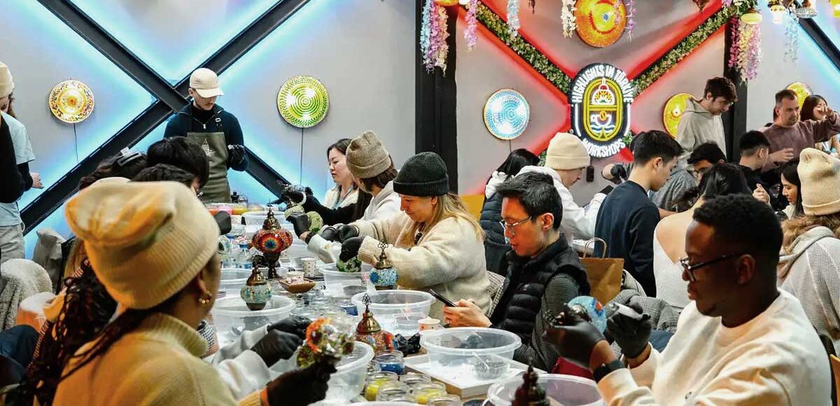 Tourists making colorful mosaic lamps in Cappadocia studio